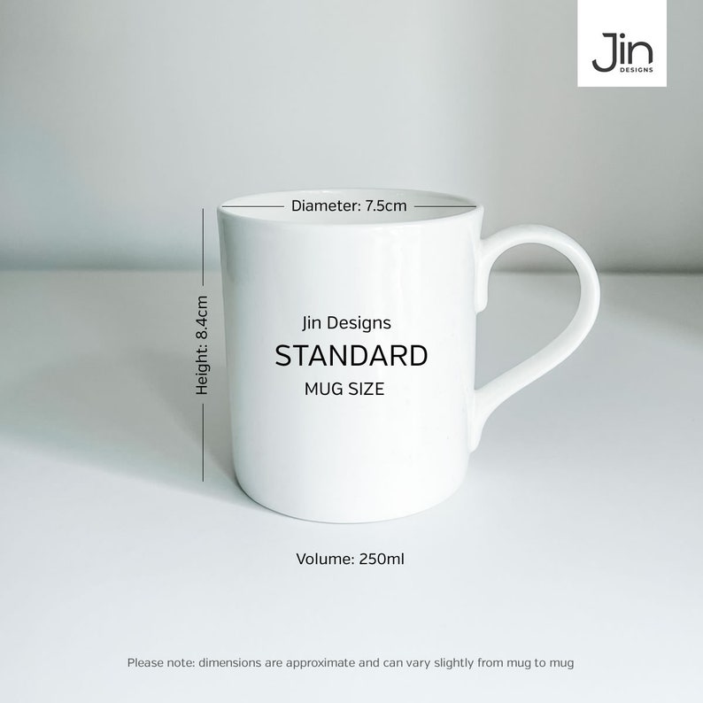 May include: White ceramic mug with black text that reads "Jin Designs STANDARD MUG SIZE". The mug has a handle and measures 7.5 inches in diameter and 8.4 inches in height. The mug holds 250 milliliters.