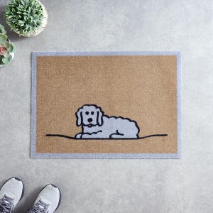 May include: A rectangular doormat with a light brown center and a gray border. The mat features a simple illustration of a gray dog lying down, with black outlines. The dog is facing left.