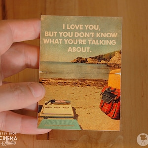 May include: A vintage-style postcard with a beach scene and the text "I love you, but you don't know what you're talking about."