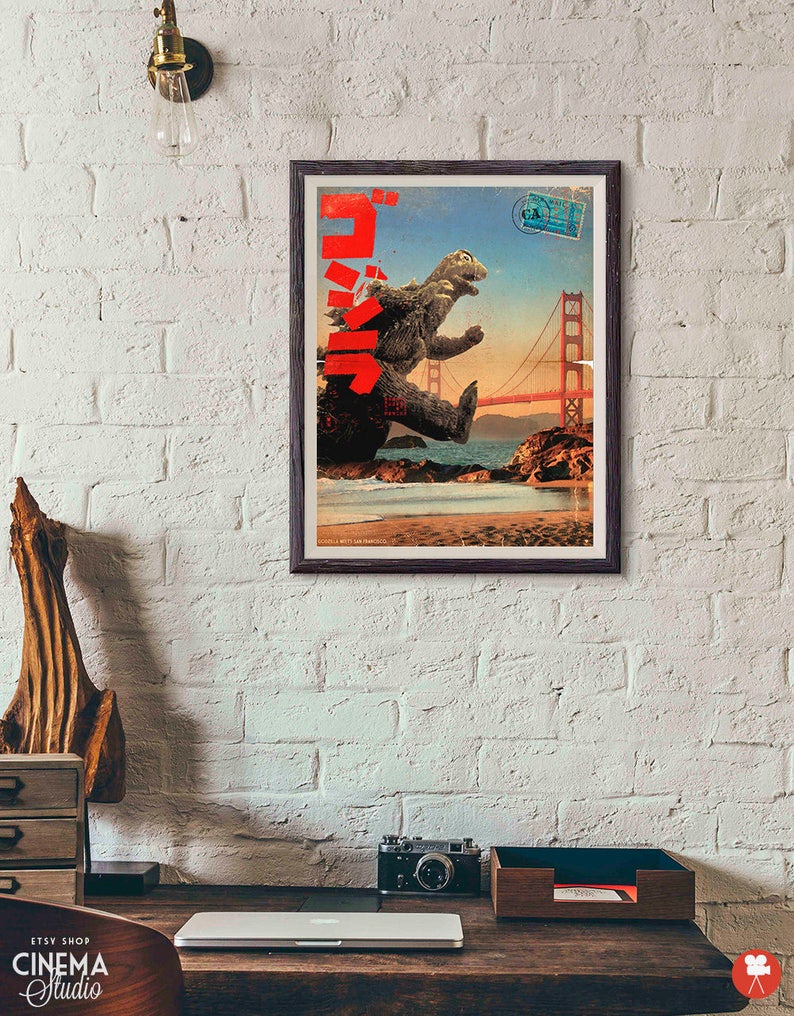 May include: A vintage movie poster featuring Godzilla, a giant monster, standing on a beach with the Golden Gate Bridge in the background. The poster is in Japanese and English and has a red, white, and blue color scheme.