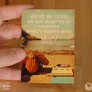 May include: A vintage-style postcard with a beach scene and the text "WE'RE IN LOVE. WE JUST WANT TO BE TOGETHER. WHAT'S WRONG WITH that?"