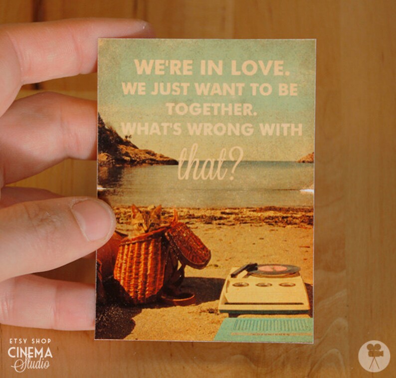 May include: A vintage-style postcard with a beach scene and the text "WE'RE IN LOVE. WE JUST WANT TO BE TOGETHER. WHAT'S WRONG WITH that?"