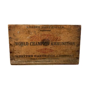 May include: Vintage wooden ammunition box with the text "LOADED SHOT SHELLS" and "WORLD CHAMPION AMMUNITION." The box is from the Western Cartridge Company, East Alton, Illinois, and is marked "SMALL ARMS AMMUNITION MADE IN U.S.A."