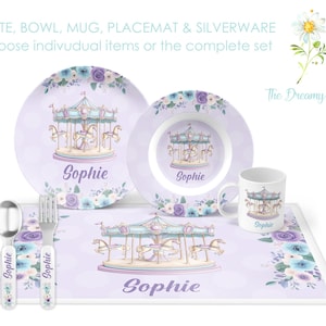 May include: A purple and blue children's dinnerware set with a carousel design. The set includes a plate, bowl, mug, placemat, fork, and spoon. The name "Sophie" is personalized on each piece.