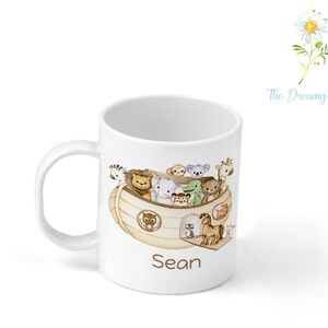 Pu&ograve; includere: Tazza in ceramica bianca con un'illustrazione marrone e beige di animali su una barca. Il testo "Sean" &egrave; stampato sulla tazza.