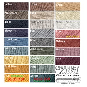 May include: A color chart displaying twenty-four swatches of crinkled muslin fabric in various shades including Sable, Fawn, Khaki, Mushroom, Sand, Cream, Black, Light Gray, Natural White, Blueberry, Fog, Rose, Cornflower, Dove, Nutmeg, Misty Blue, Ash Green, Mauve, Custard, Celadon, Plum, Dark Dijon, Sage, and Spruce, with text labels and a Charley Charles logo.