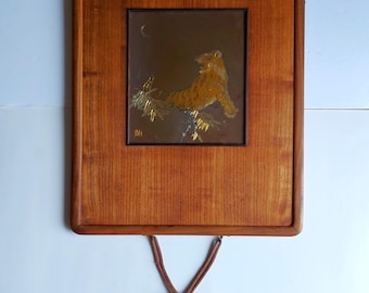 Tigre asiático grabado y firmado sobre latón detrás de un cristal en madera maciza con borlas.
