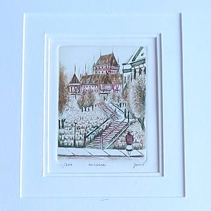 May include: A framed watercolour print depicting a European townscape, with a prominent building and a descending staircase. The print is numbered 161/250 and signed. The artwork is presented within a white mount.