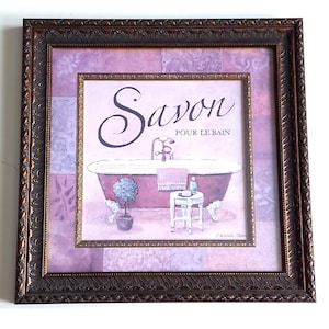 May include: Framed artwork depicting a vintage bathroom scene with a purple clawfoot tub. The artwork includes the word "Savon" and "Pour le Bain". The frame is dark brown with ornate detailing, and the background is a patchwork of purple squares.