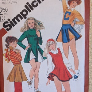 May include: Simplicity sewing pattern number 5598 for girls' skirts. The pattern includes four different skirt styles: a green and white skirt, a red skirt, a brown and orange striped skirt, and a blue and gold cheerleader skirt. The pattern is for sizes 9/10 and 11/12.