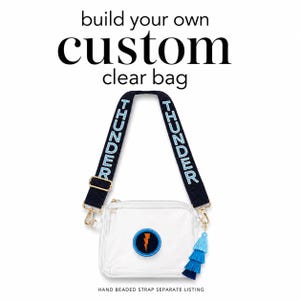 May include: A clear, square bag with a navy blue and light blue beaded strap that says "THUNDER". The bag has a lightning bolt patch and a blue tassel. Text at the top says "build your own custom clear bag".