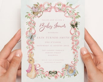 May include: A light blue baby shower invitation with pink ribbon and floral accents. The invitation features illustrations of Peter Rabbit and other woodland creatures. The text reads "Please join us for a Baby Shower honoring Erin Turner-Smith One O'Clock Saturday 12 August 2025 The Garden Terrace Poster Street Rakewell"