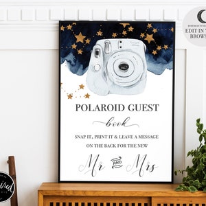 May include: A printable sign for a wedding or party, featuring a blue watercolour background with gold stars and a white Polaroid camera. The text reads "Polaroid Guest Book" with a handwritten font. The sign also includes the text "Snap it, print it & leave a message on the back for the new Mr. & Mrs."