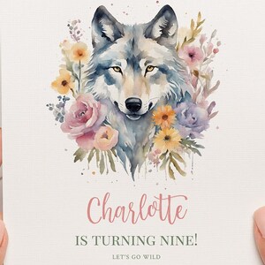 May include: A watercolour illustration of a wolf's head surrounded by pink, yellow, and purple flowers. The text "Charlotte is turning nine! Let's go wild AUG" is below the image.