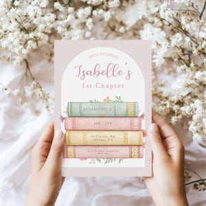 Puede incluir: Una tarjeta de invitación rosa y blanca con una pila de libros coloridos y detalles florales. El texto dice "Únete a nosotros para celebrar el primer capítulo de Isabelle, sábado 5 de octubre, 13:00-17:00, 10 Canyon Rd., Malibu, CA, RSVP a Keely 01234567890 antes del 17-12-13."