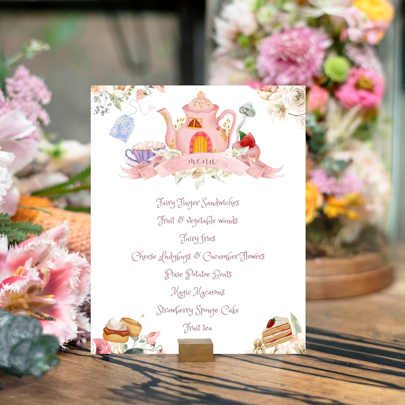 May include: A whimsical menu card featuring a pink teapot house illustration with the word "menu" on a banner. The menu lists "Fairy Finger Sandwiches", "Fruit & Vegetable wands", and other fairy-themed food items. The card is propped up on a wooden surface.