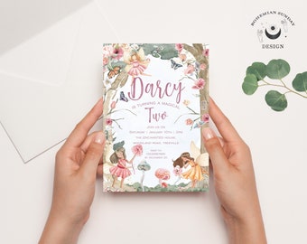 Può includere: Un invito di compleanno a tema fatato per un bambino di due anni, tenuto in due mani. L'invito presenta il testo "Darcy is turning a magical Two" con illustrazioni di fate, fiori e farfalle. Il design è in stile acquerello.