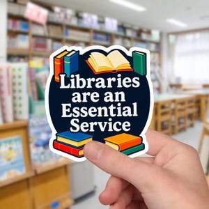May include: A sticker with a blue background and white outline, featuring a stack of books, an open book, and the text "Libraries are an Essential Service".