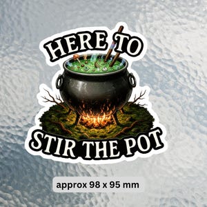 May include: A sticker depicting a black cauldron with green liquid, mushrooms, and eyeballs. The cauldron is above a fire, with the text "HERE TO STIR THE POT" in a white banner. The sticker is approximately 98 x 95 mm.
