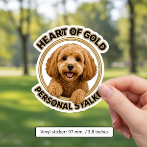May include: A circular vinyl sticker measuring 3.8 inches featuring a brown curly-haired dog inside a gold frame. The text reads HEART OF GOLD and PERSONAL STALKER in black capital letters. The dog has floppy ears and a happy expression.