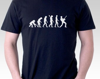 May include: A black t-shirt featuring a white graphic of the evolution of man, culminating in a man playing a guitar.