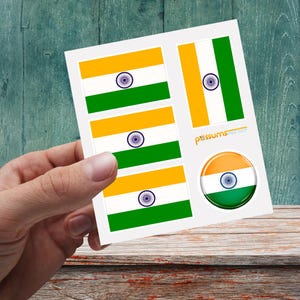May include: A sheet of stickers featuring the Indian flag. The stickers include rectangular and circular designs with orange, white, and green stripes, and a blue wheel emblem. The text "pxssums" is visible.