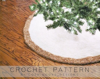 Könnte beinhalten: Ein runder, weißer, strukturierter Baumteppich mit einem dicken, beigen Häkelrand, der auf einem Holzboden unter einem beleuchteten Weihnachtsbaum liegt. Der Text unten lautet CROCHET PATTERN BY COZY NOOKS DESIGNS.