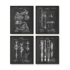 May include: Set of four vintage woodworking tool patent prints on a black chalkboard background. The prints feature drawings of a hand plane, a saw, a drill, and a screwdriver. Each print includes the patent number, inventor's name, and date.