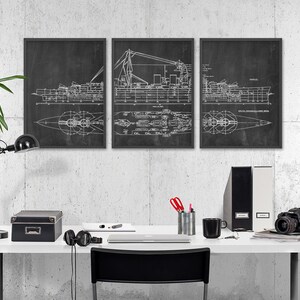 K&ouml;nnte beinhalten: Drei schwarze gerahmte Drucke eines Schiffsbauplans an einer wei&szlig;en Wand &uuml;ber einem wei&szlig;en Schreibtisch mit einer schwarzen Lampe, einer schwarzen Box, einer Kamera und einem schwarzen Stuhl.