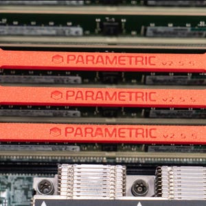 May include: Three red clips with the text "PARAMETRIC" on them are attached to three black memory modules. The memory modules are installed in a computer motherboard.