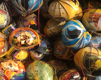 Könnte beinhalten: Nahaufnahme einer Sammlung von bunten, handgefertigten Ornamenten aus Pokémon-Sammelkarten. Die Ornamente sind kugelförmig und zeigen verschiedene Pokémon-Charaktere, darunter Arkani, Relaxo und Pikachu.