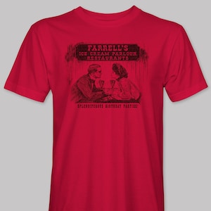 May include: Red t-shirt with a black and white illustration of a couple sitting at a table with the text "Farrell's Ice Cream Parlour Restaurants Splendiferous Birthday Parties!"