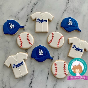Pu&ograve; includere: Un set di nove biscotti decorati a tema baseball e Los Angeles Dodgers. I biscotti sono decorati con glassa blu, bianca e rossa. I biscotti includono palline da baseball, maglie da baseball e cappellini da baseball.