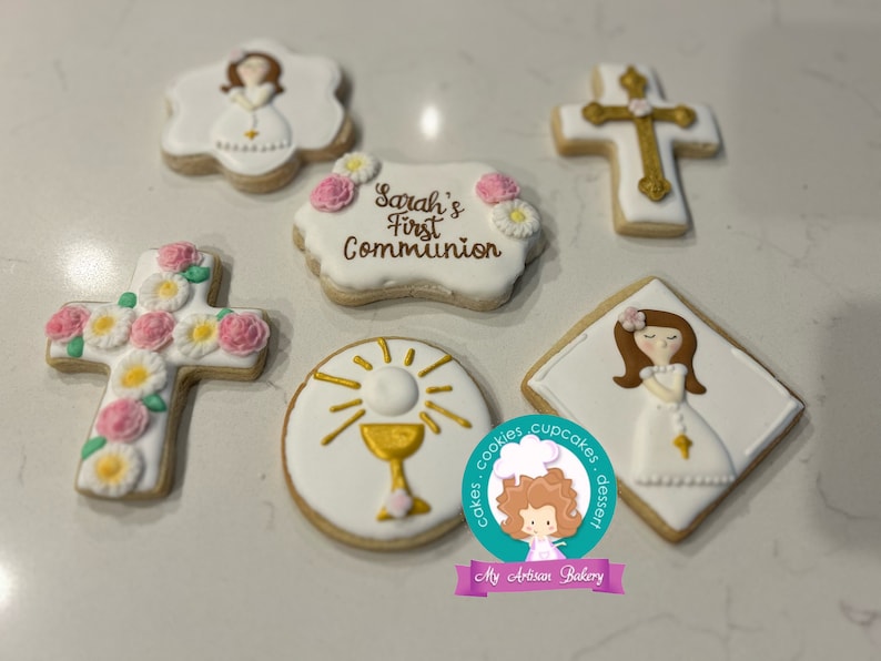 May include: A set of six decorated sugar cookies featuring a cross with flowers, a chalice, a girl in a white dress, and the text "Sarah's First Communion".