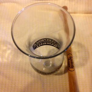 May include: A clear glass with the word "BASEBALL" printed on it, and a Louisville Slugger wooden baseball bat.