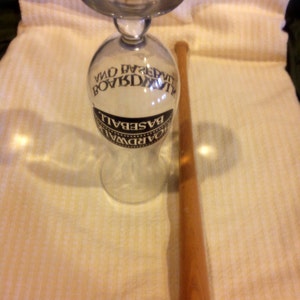 May include: A clear glass with a black and white label that reads "Boardwalk Baseball" and a wooden baseball bat.