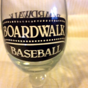 May include: A clear glass with a black and white design that says "Boardwalk Baseball".