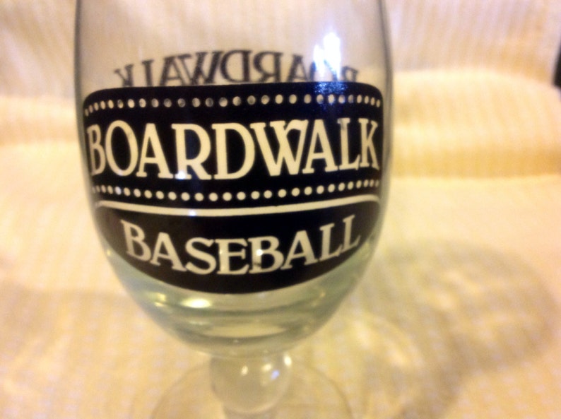 May include: A clear glass with a black and white design that says "Boardwalk Baseball".