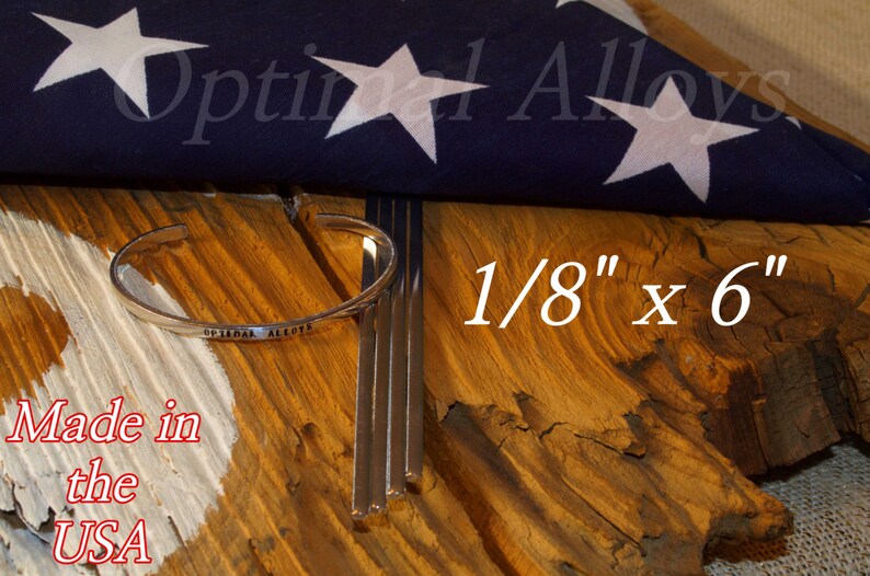 May include: Four silver metal rods, 1/8 inch by 6 inches, with a silver metal bracelet that says "Optimal Alloys" on it. The rods and bracelet are on a wooden surface with a folded American flag in the background. The text "Made in the USA" is visible in the lower left corner.