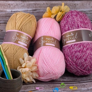 May include: Three balls of yarn in pink, beige, and pink and white speckled. The yarn is labeled "Stylecraft Special Double Knit".