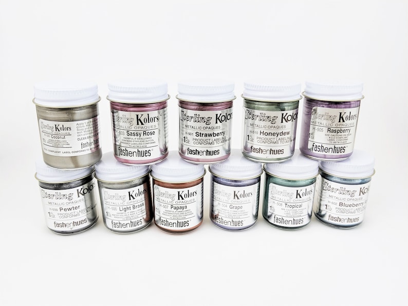 May include: Ten small jars of metallic opaque paint in various colors, including coconut, sassy rose, strawberry, honeydew, raspberry, pewter, light brass, papaya, grape, tropical, and blueberry. Each jar is labeled with the color name and "Sterling Kolors" with the tagline "fashenhues".