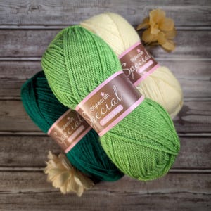 May include: Three skeins of Stylecraft Special double knit yarn in shades of dark green, bright green, and cream. Each skein features a brown paper label with the text Stylecraft Special double knit printed in white and pink lettering.