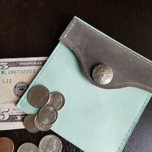 Portmonetka ze skóry nubukowej w kolorze niebieskim Robin's Egg z akcentem z polerowanej skóry licowej w kolorze szarym na klapie zamykanej na zatrzask