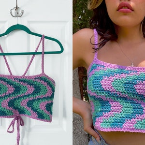 Op de afbeelding: Een gehaakt crop top met een geometrisch patroon in roze en groen. De top heeft dunne bandjes en knoopt aan de achterkant.