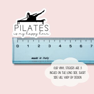 May include: A black and white sticker with a silhouette of a person doing pilates on a reformer. The text "PILATES is my happy hour" is written below the image. The sticker is 3 inches long.