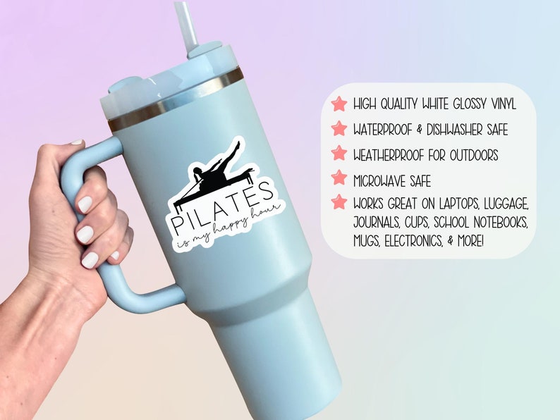 May include: A blue stainless steel tumbler with a black and white vinyl sticker that says "PILATES is my happy hour". The sticker features a silhouette of a person doing pilates on a reformer. The tumbler has a handle and a straw.