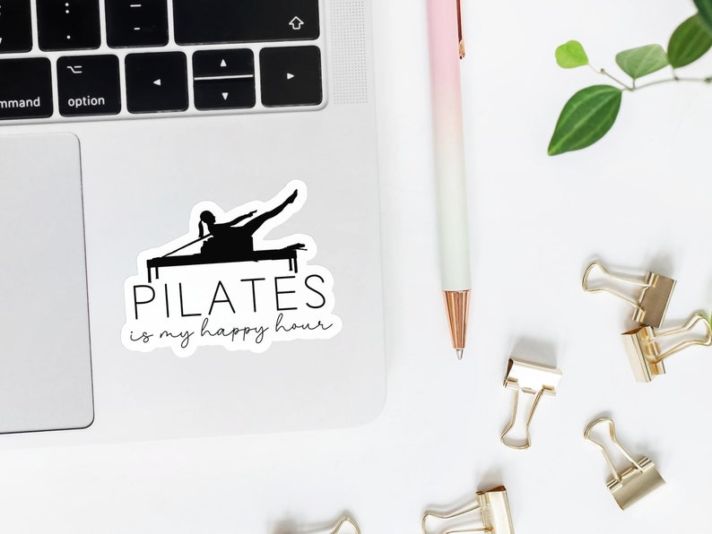 May include: A white sticker with a black silhouette of a person doing pilates on a reformer. The text "PILATES is my happy hour" is written below the silhouette.