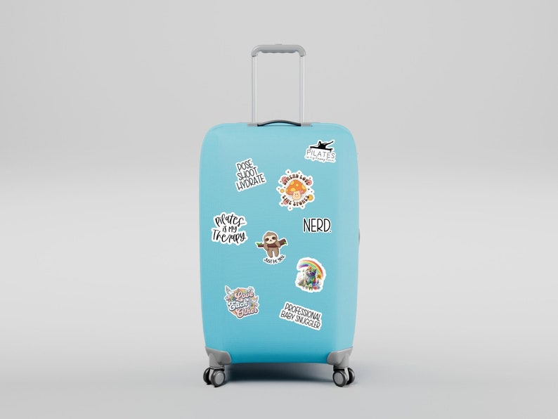 May include: A light blue suitcase with various stickers on it. The stickers include a sloth, a rainbow, a mushroom, and text that says "Pilates is my therapy", "Pose, Sweat, Hydrate", "Nerd", "Professional Baby Snuggler", and "Good Vibes Only".
