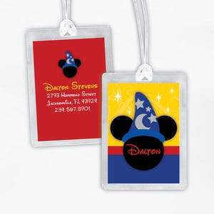 以下が含まれることがあります： 白いコードが付いた2つの透明なプラスチック製の荷物タグ。1つのタグは、青い魔法使いの帽子をかぶった漫画のミッキーマウスの頭が赤い背景にあります。もう1つのタグは、同じ漫画のミッキーマウスの頭と「Dalton」という名前の黄色い背景です。