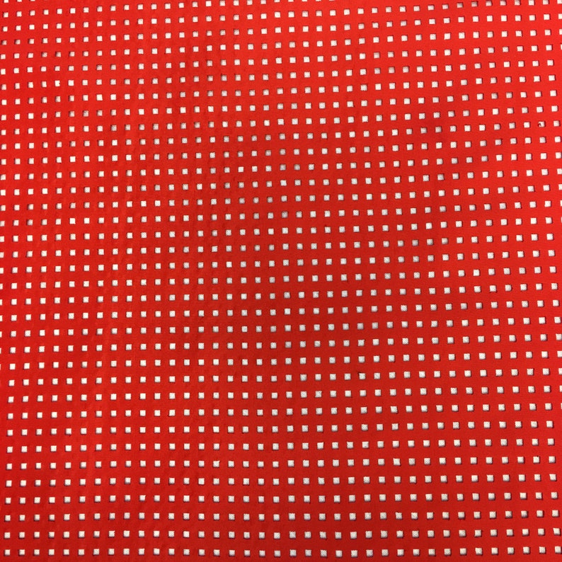 May include: Red fabric with a white grid pattern. The fabric has a textured surface.